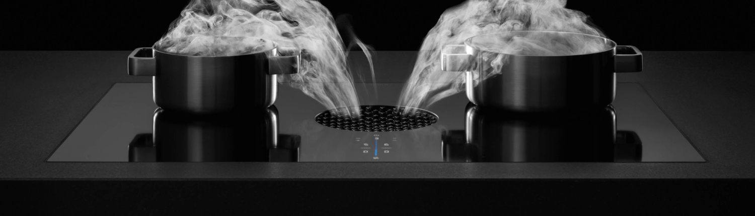 Bilde av BORA_X-Pure_benkeventilator hvor du ser at dampen forsvinner ned i ventilatoråpningen fra 2 gryter som koker