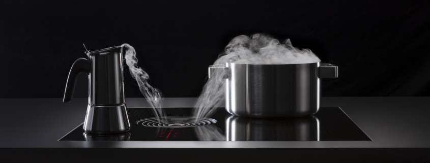 Bilde av BORA X Pure benkeventilator i profil som viser damp som forsvinner ned i avtrekksåpningen som sitter mellom kokesonene.